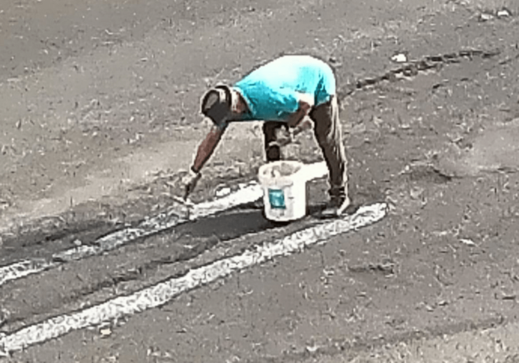 Un vecino pinta la calle Fernando Sagaseta para advertir de los socavones / TA